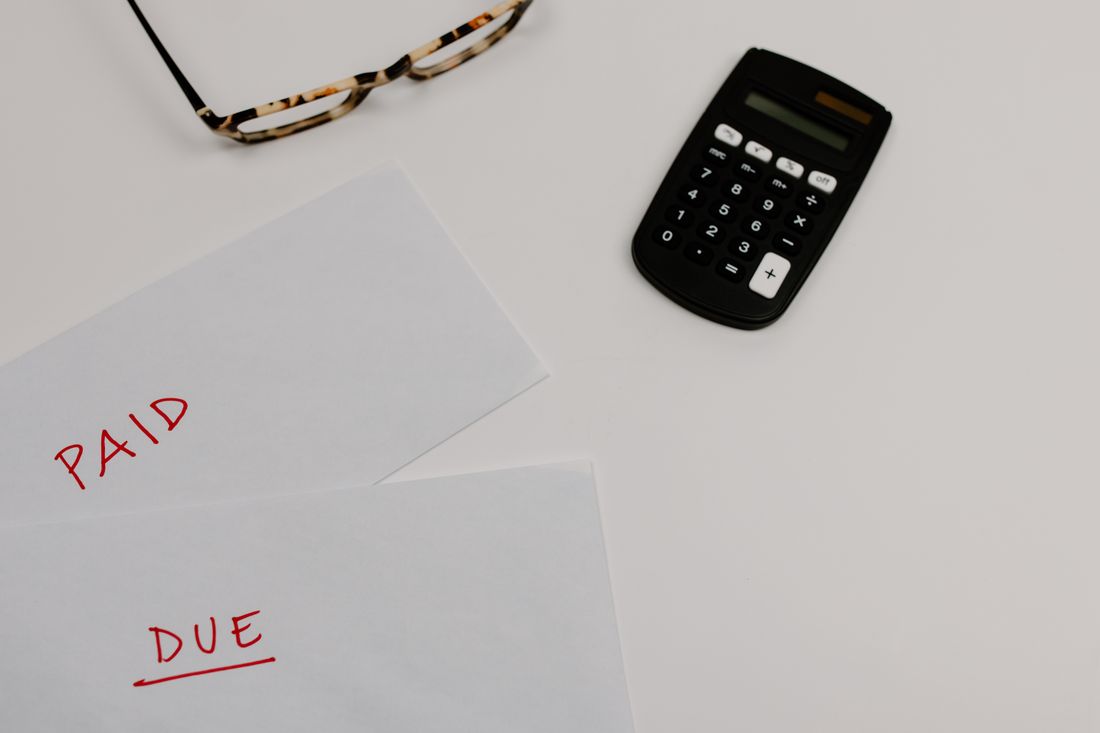 Invoices and a calculator on a desk